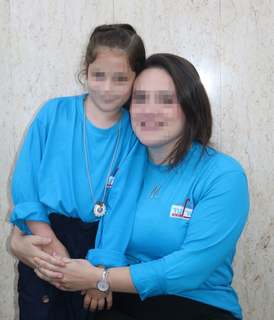 Keren Hayeled dorm counselor with her arms around a young student in the orphanage