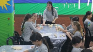 Girls at the Keren Hayeled Orphanage in Israel, rolling and shaping dough to bake Challahs